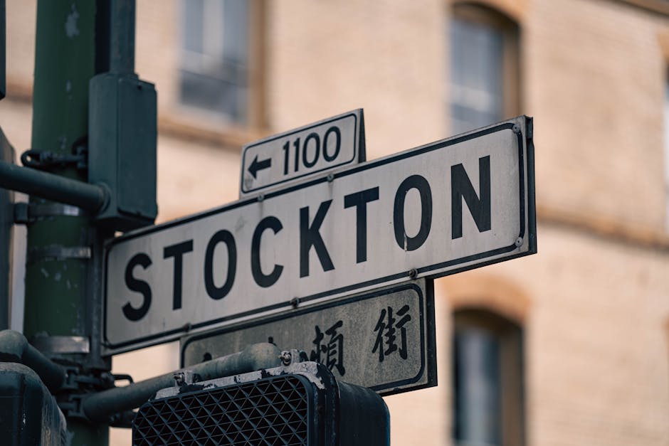 Street sign in Stockton with directional arrows, shot at an intersection, capturing city life.