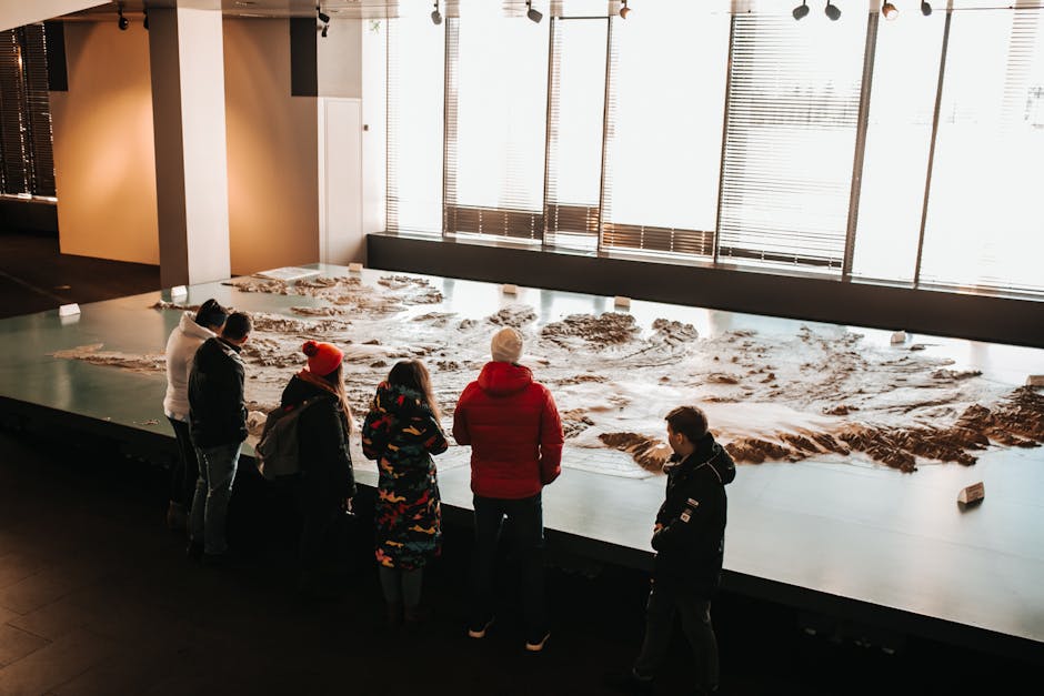 Group of adults exploring a large map exhibit in a museum setting during winter.